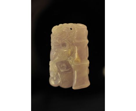 A lilac jade pendant carved with a dragon