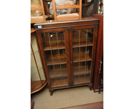 A small oak bookcase with lead light glazed doors