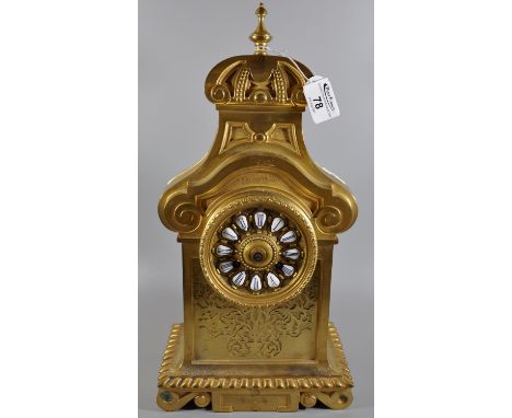 Brass mantel clock with scrolled pediment above Roman ceramic face and pierced panels below, brass drum movement strikes on o