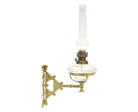 An Aesthetic Movement brass wall mounted oil lamp, in the style of Christopher Dresser, the articulated arm cast with Egyptia