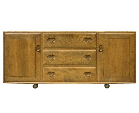 An Ercol Windsor sideboard, light elm and ash, three drawers flanked by cupboards, on caster feet, 156cm wide, 70cm high, 44c
