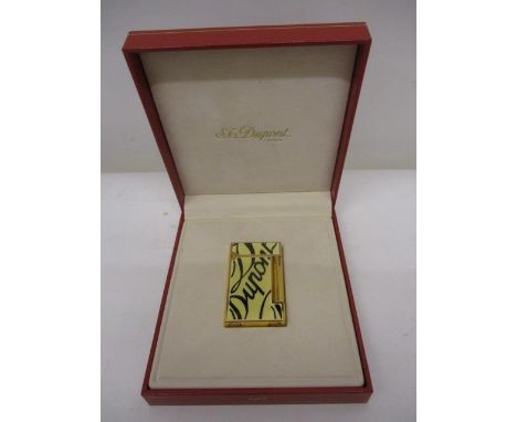 A DuPont gold plated lighter with cream panels and black writing, in a hard case 