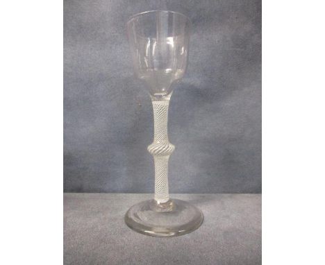 An 18th century opaque twist wine glass, with ogee bowl on a multi spiral opaque twist stem with central cushion, on conical 