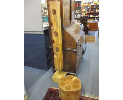 A contemporary oak and brass bespoke wine holder in the form of a column, together with another wooden wine holder in the for