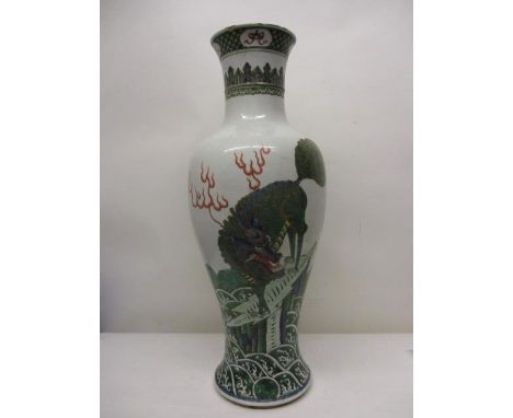 A 19th century Chinese porcelain vase of ovoid form with a flared lip and foot decorated with a mythical beast on a rock, wit