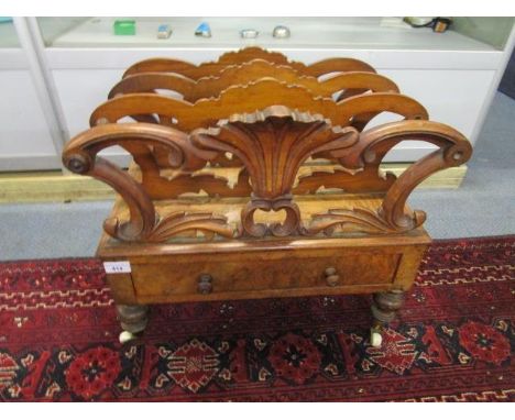 A William IV walnut Canterbury, the sections united by turned spindles, the base with a single drawer on turned legs and cera