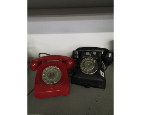 A black Bakelite telephone with a drawer and a vintage red cased telephone 