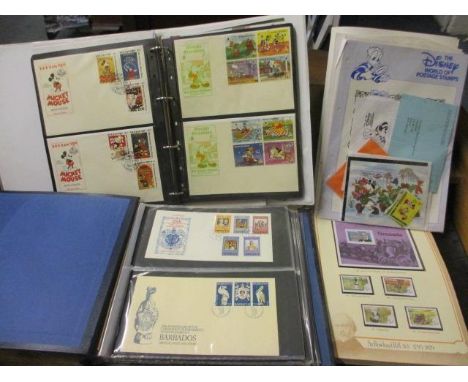 Two commemorative stamp albums containing first day covers, together with an album containing Disney related stamps and cover