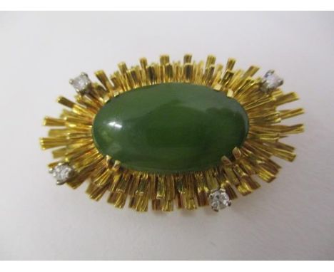 A gold coloured metal oval brooch set with a jade cabochon, within a spindle border, set with four diamonds, stamped 18ct DAB