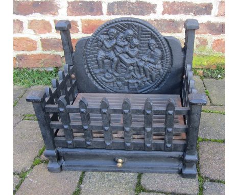 Cast iron fire grate with figural fire back 41cm wide, 27.5cm deep, 36cm at highest point