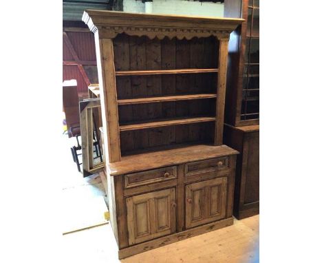 A late 19thc pine dresser the projecting dentil cornice over three height plate rack with two drawers to base above two cupbo