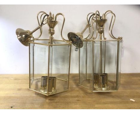A pair of modern brass and glass hexagonal hall lanterns with bevelled glass panels and three lamp holders each, measures 45c