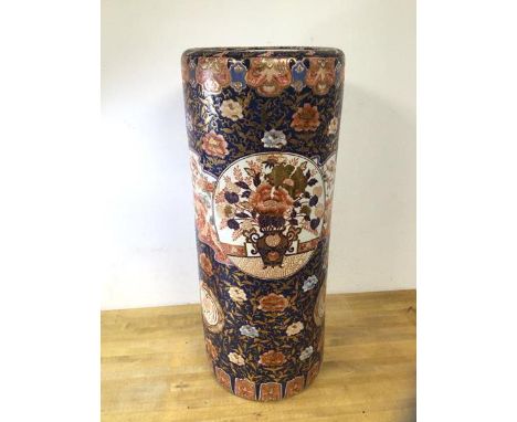 A Chinese cylindrical stick stand with floral and gilt decoration and wooden base, measures 63cm x 26cm