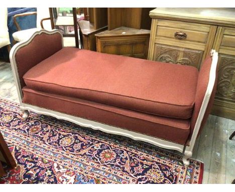 An early 20thc French daybed, the cream painted moulded frame upholstered in a herringbone wool fabric with squab cushions, r