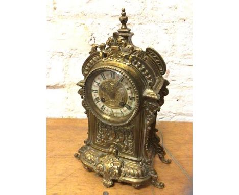 A late 19th early 20thc brass rococo inspired mantel clock, the enamel dial with roman numerals, measures 34cm high