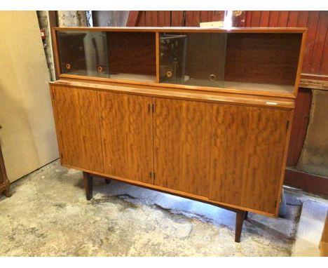 A Gimpson &amp; Slater Ltd, a mid century teak side cabinet, the super structure with  twin sliding glass doors over further 