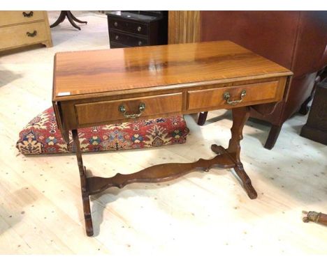 A reproduction Georgian style mahogany sofa table, the cross banded top with two shaped drop leaves over two drawers, raised 