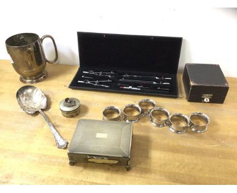 A mixed lot of Epns including a set of six napkin rings, cigarette box, mug, spoon and pill box, also a boxed set of compasse