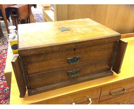 An Edwardian oak canteen, the top with inlaid metal star of Masonic interest, the hinged top has twin locking pilasters over 