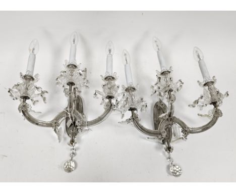 Pair of triple light glass wall sconces, each with 18th century-style nozzles and faceted drops, on an oval wall plaque, elec