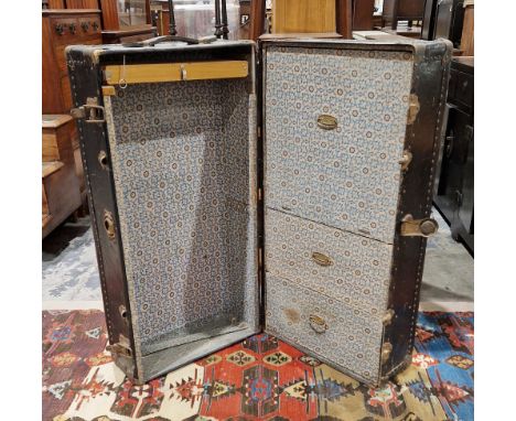 Early 20th century black leather and iron bound studded travelling wardrobe trunk, fitted with three drawers and wooden hange
