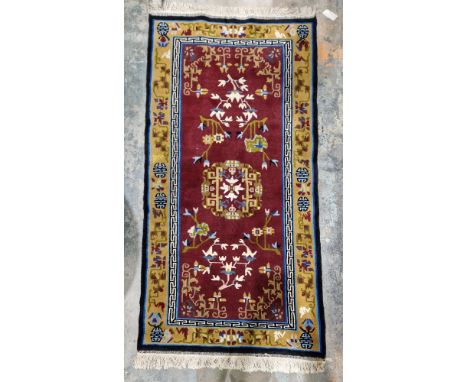Chinese superwash burgundy ground rug, central floral medallion on stylised floral field, multiple geometric and floral borde