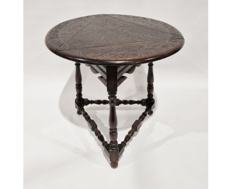 Victorian oak occasional table, the circular top with three drop leaves and carved leaf decoration, over three turned support