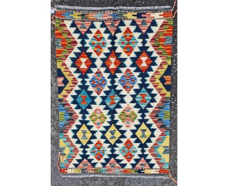 Chobi kilim, woven with a geometric medallion in red, blue and ochre reserved on a cream ground within a colourful geometric 