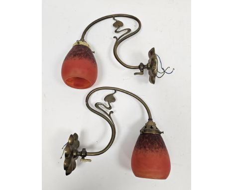 Pair of Art Nouveau brass wall lights&nbsp;with S-shaped tendril branches and lobed wall mounts, with orange tinted mottled b