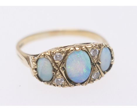 Opal three stone ring, the largest approx. 7mm x 5mm, dispersed with tiny white gemstones set in 9ct gold, size P, gross weig