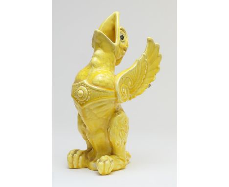 In the manner of Burmantofts, a yellow glazed pottery vase in the form of a griffin, with original glass eyes, height 31cm (P