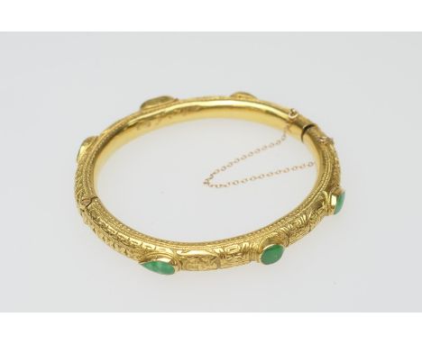 Eastern made yellow gold and jade set hinged bangle, with chased decoration, the stones of round, oval and pear shaped caboch