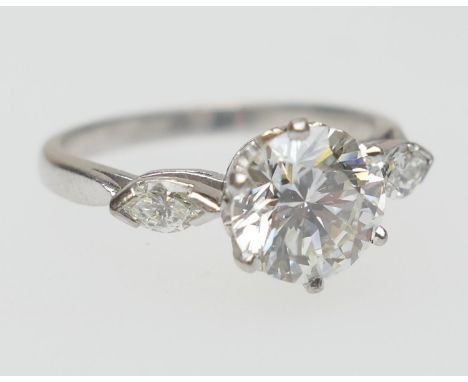 Diamond three stone ring, centred with a round brilliant cut diamond of approx. 1.5cts, certificated as J/K colour and SI cla
