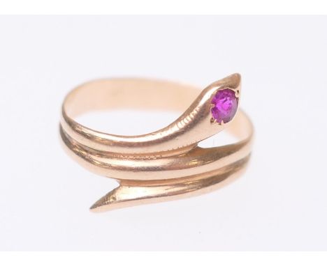 Yellow gold and ruby snake ring, the head of the serpent set with a single round cut ruby, the ring indistinctly marked, test