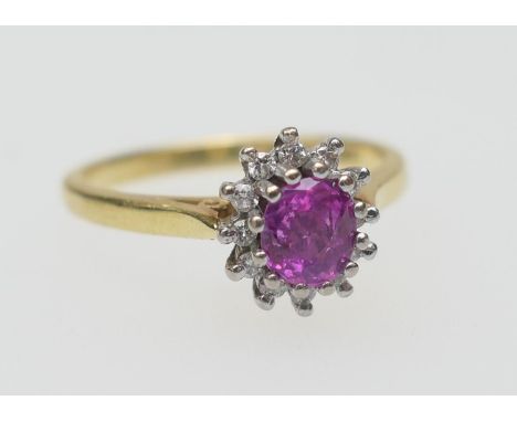 Ruby and diamond cluster ring, the oval ruby (untested) of approx. 0.25ct, bordered with twelve tiny brilliant cut diamonds, 