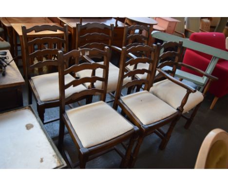 A set of six ladder back dining chairs with cream upholstered seats including two carvers and four dining chairs on turned le