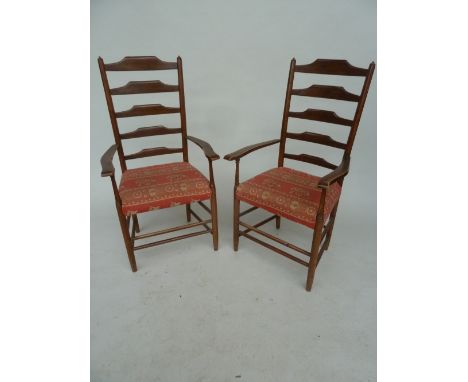 A pair of ladder-back carver dining chairs upholstered with a red Indian style fabric with Elephants and Camels 