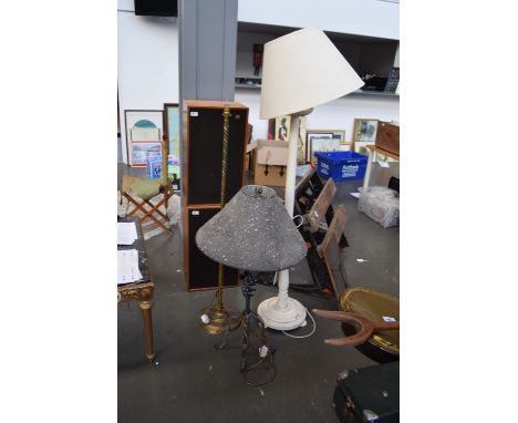 A brass standing lamp with turned stem, a white painted wooden standing lamp with cream shade and one other lamp with texture