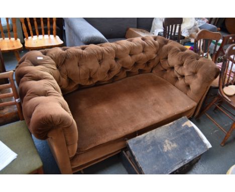 A two seater button back Chesterfield sofa upholstered in brown fabric