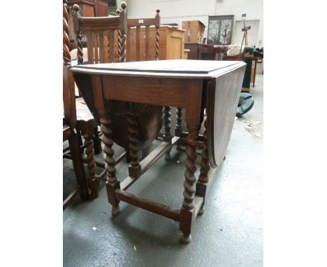 An oak oval gate leg dining table on barley twist legs 106cmW