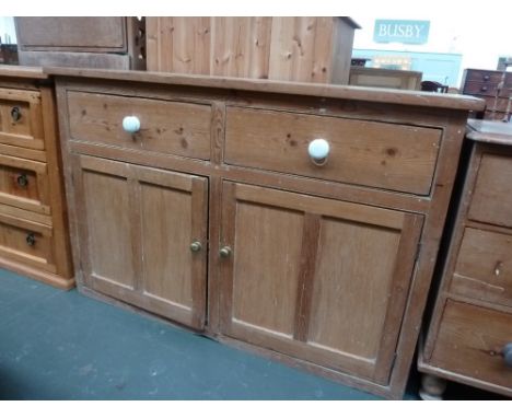 A Victorian pine dresser base with two short drawers over two cupboards with internal shelf and white painted round handles 1