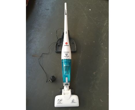 A Hoover Free Jet Cyclonic battery powered 14.4V hoover and charger with a box of miscellaneous tools