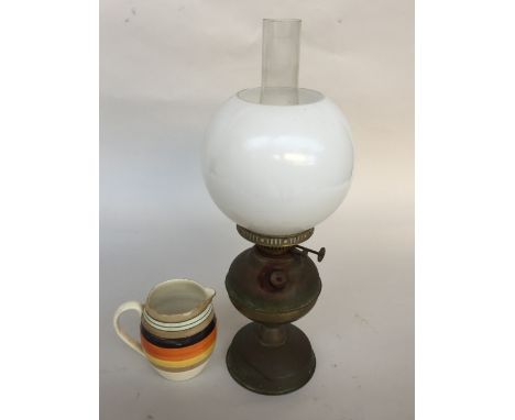 An oil lamp and shade together with a striped milk jug by Oriental Ivory Bishop china