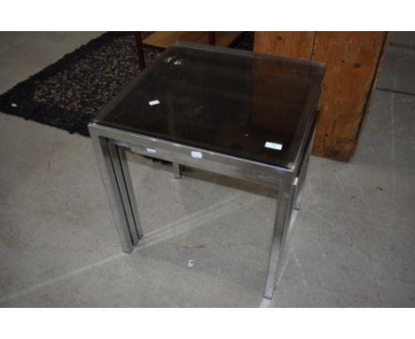 A vintage chrome nest of three tables with glass tops