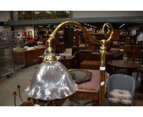 An Art Nouveau style brass standard lamp having pressed glass shade
