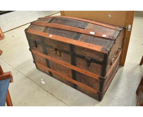 A large vintage dome top bedding trunk having leather strap work, width approx. 94cm
