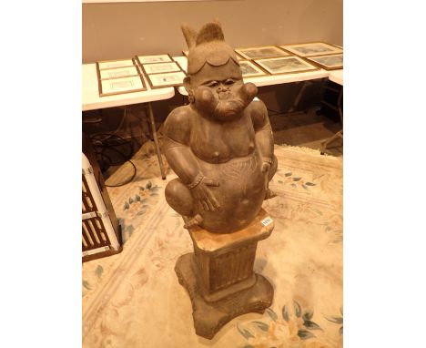 Large terracotta figure on a ceramic pedestal