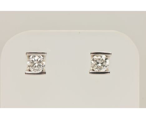 A PAIR OF WHITE METAL DIAMOND STUD EARRINGS, each earring tension set with a round brilliant cut diamond, estimated total dia