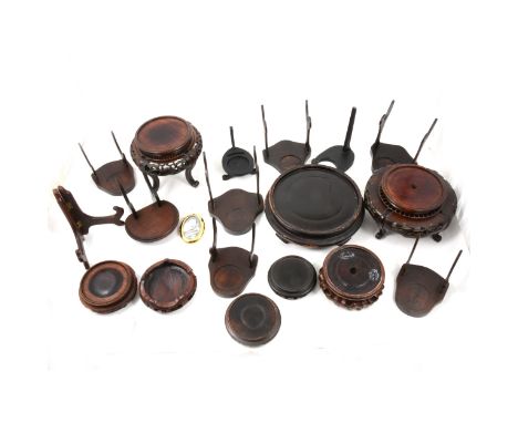 A quantity of Chinese hardwood stands, some turned and pierced, others for displaying cups and saucers/ plates, various sizes