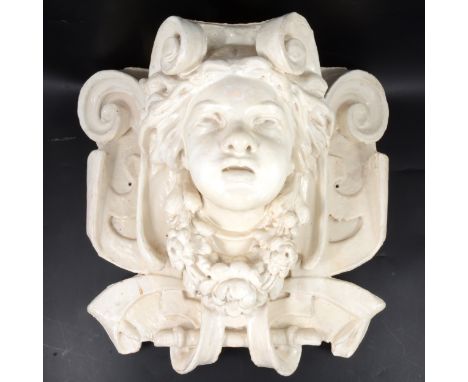 Della Robbia style white glazed corbel, modelled with a cherub's face within scrolls, 43x47cm, depth 24cm.